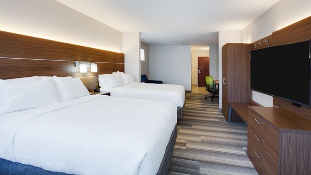 A hotel room with two beds, a flat-screen TV, wooden headboard, and a desk with a chair. - Holiday Inn Express Hotel & Suites Tampa-Fairgrounds-Casino by IHG (Tampa)
