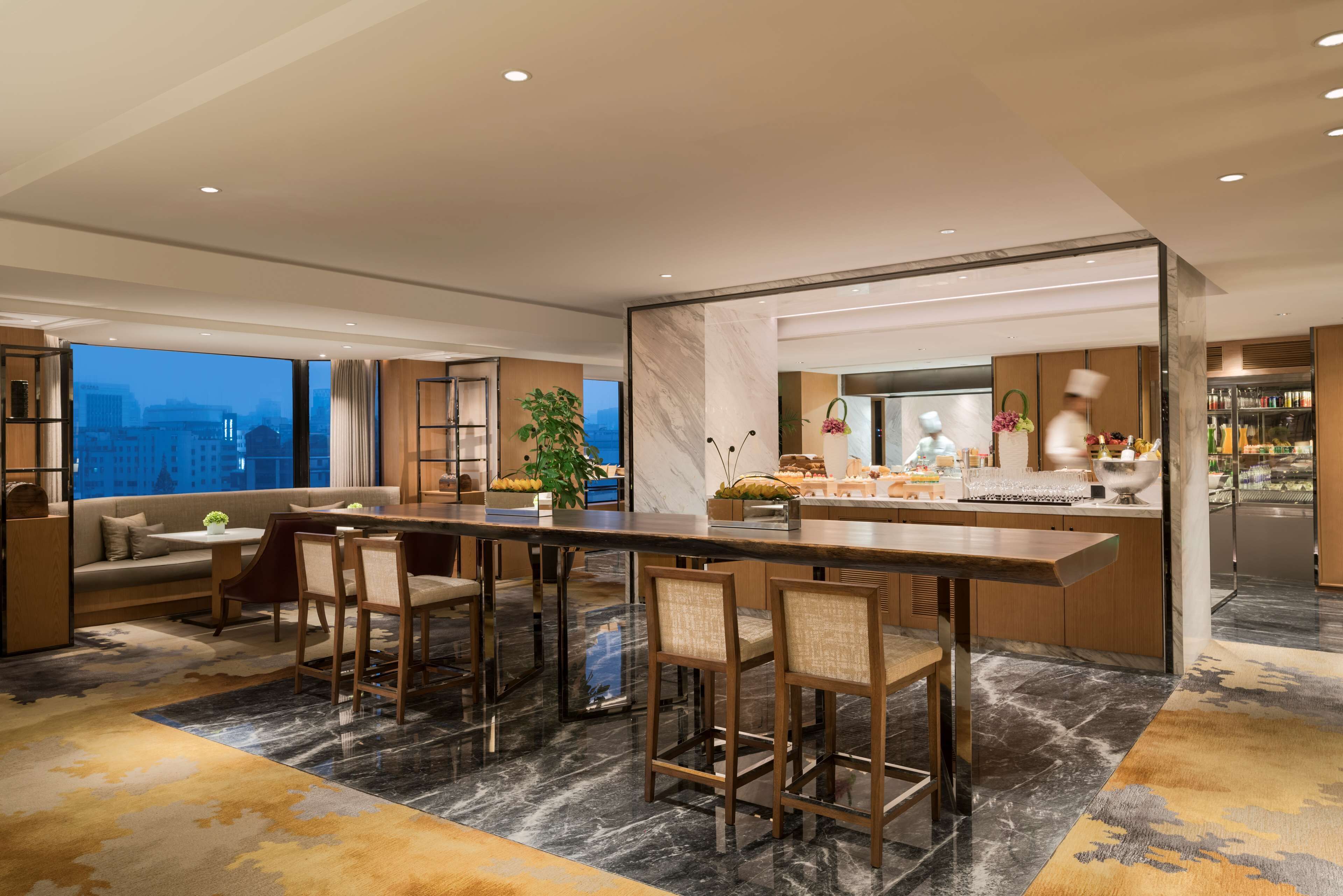 Una cocina moderna con barra, ventanas amplias y vistas a la ciudad.