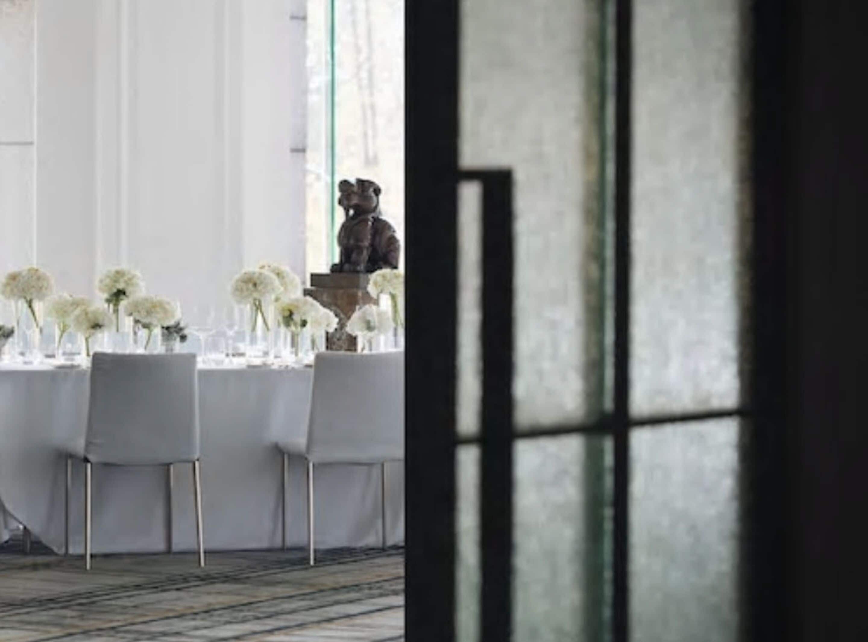 A table set with white flowers and a statue.