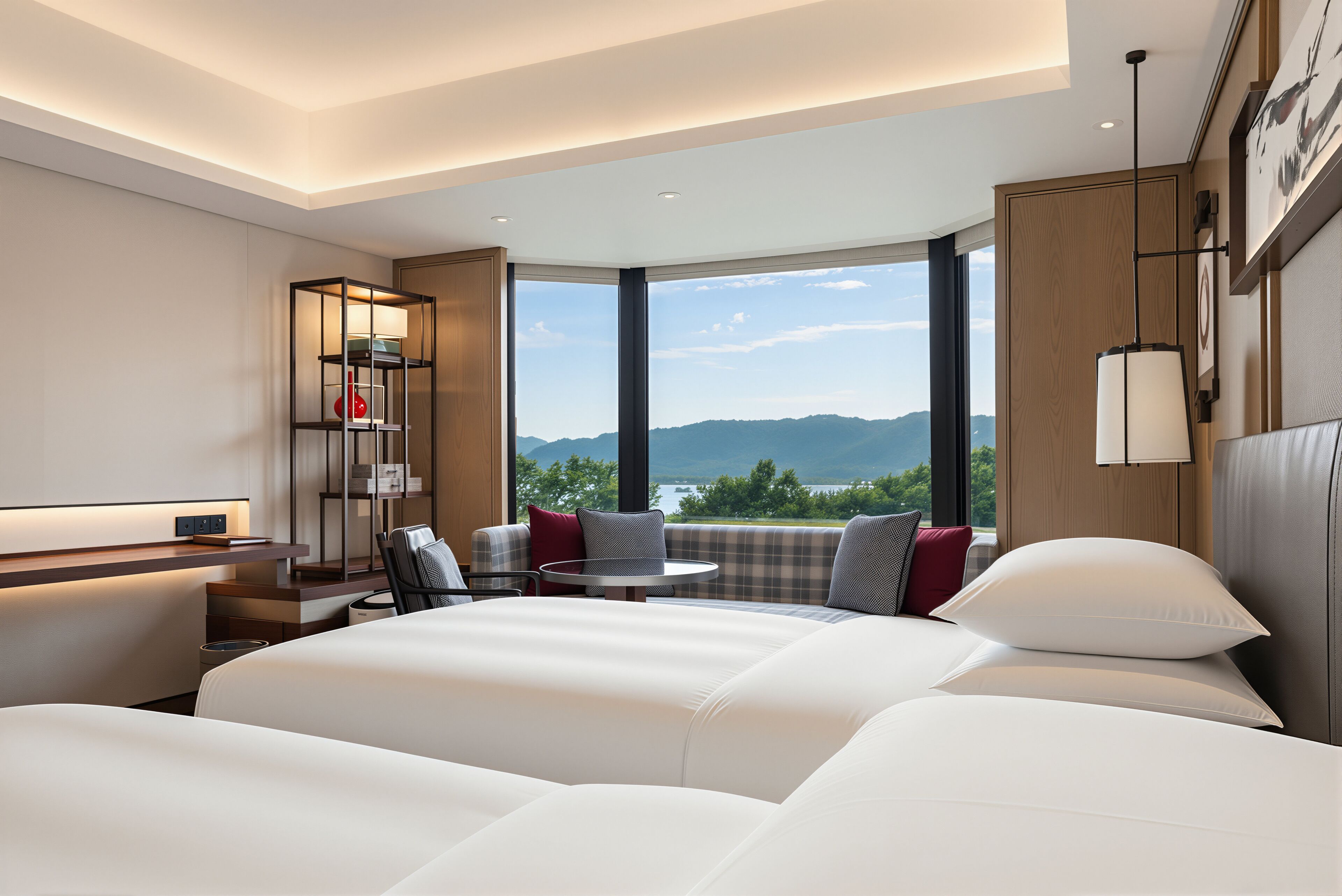 A modern hotel room with a large bed, a desk, and a view of mountains.