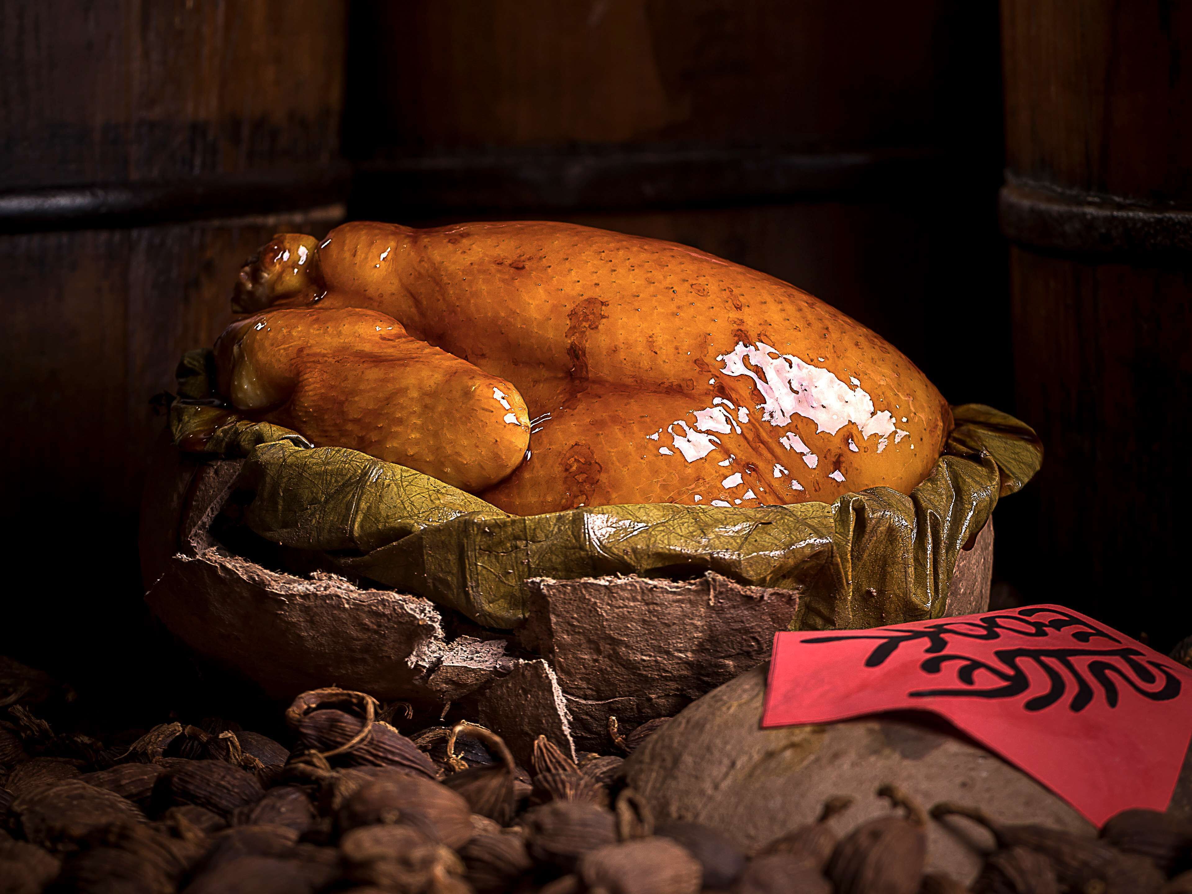 A roasted turkey on a wooden surface with a cloth and a red tag.