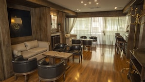 A spacious living room with a sofa, armchairs, a coffee table, and a fireplace. - Hotel Cecilia (Asunción)