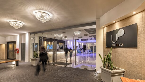 A modern hotel lobby with a reception desk, chandeliers, and a seating area. - Up Tribeca Hotel (Buenos Aires)