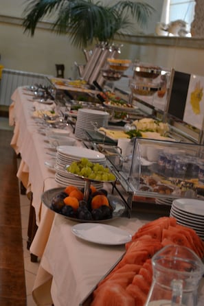 A buffet setup with various food items and a glass display case. - Hotel Morskoy (Odesa)