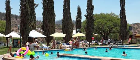 Una piscina al aire libre, sombrillas, tumbonas