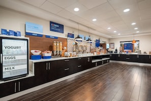 A breakfast buffet area with labeled sections for yogurt, eggs, milk, fruit, cereal, and hot food. - Holiday Inn Express McDonough by IHG (McDonough)