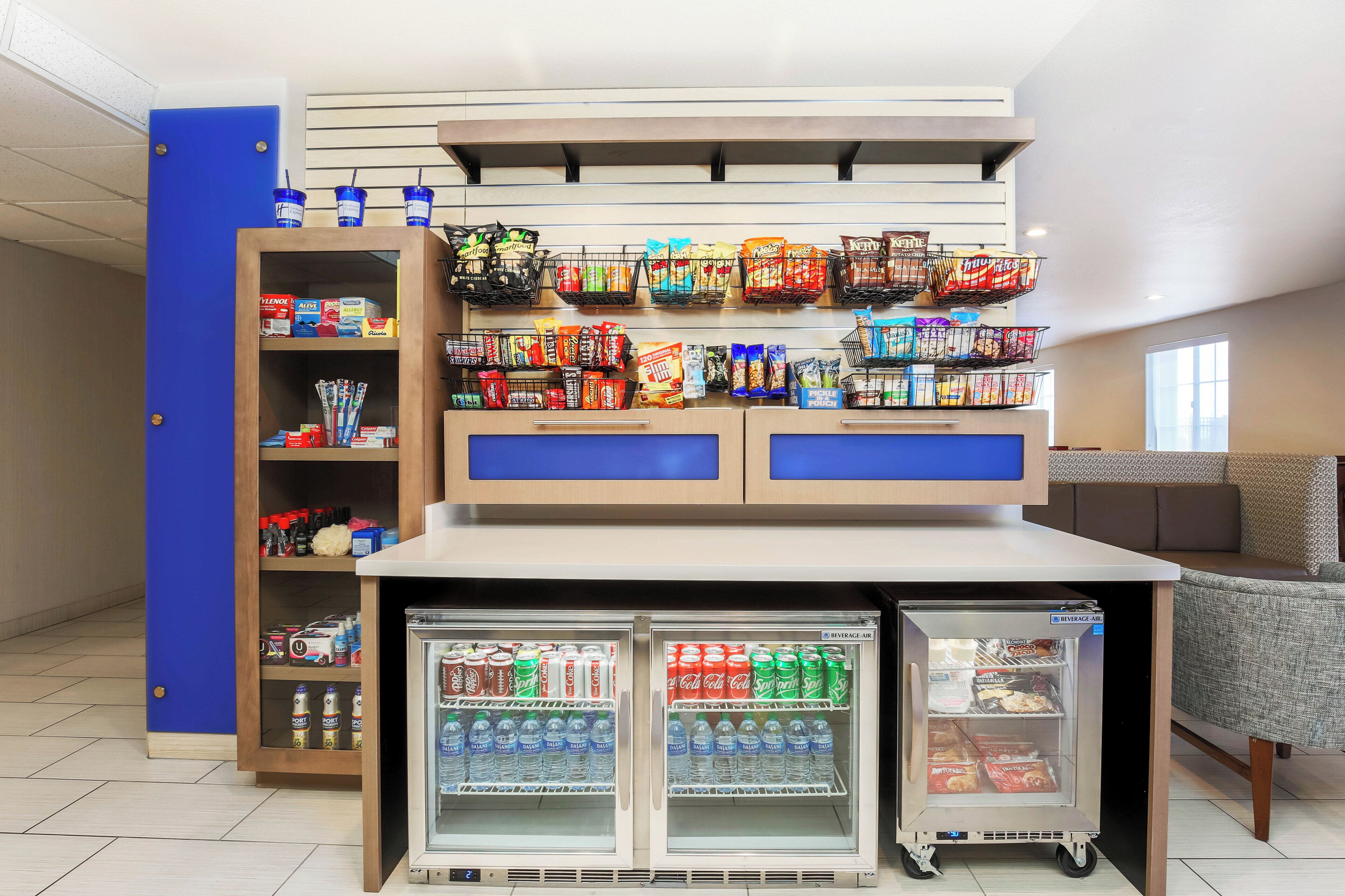 A beverage kiosk with a refrigerator stocked with drinks and snacks.