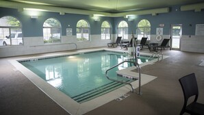 Una piscina interior con agua cristalina, múltiples carriles y barandillas de seguridad.