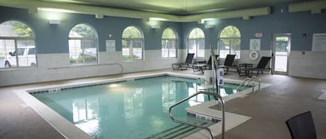 Una piscina interior con agua cristalina, múltiples carriles y barandillas de seguridad.