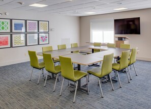 A conference room with a large table and chairs, a flat-screen TV, and framed artwork on the wall. - Holiday Inn Express & Suites Chickasha by IHG (Chickasha)