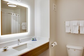 A bathroom with a white sink, mirror, and toilet.