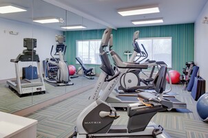 A gym with stationary bikes, treadmills, and exercise balls.