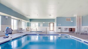 A swimming pool with a lifeguard chair, lounge chairs, and a clear view of the outdoors.