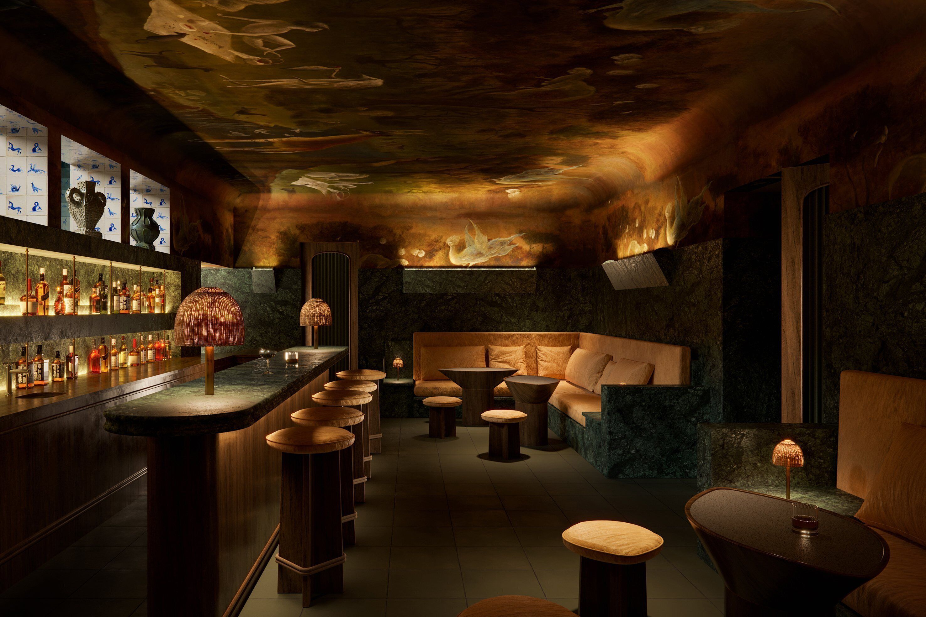 Eine Bar mit langer Theke, Hockern und einer Sitzecke mit einer Couch und Tischen.
