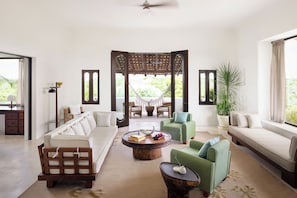 A modern living room with a sofa, armchairs, a coffee table, and a hammock.