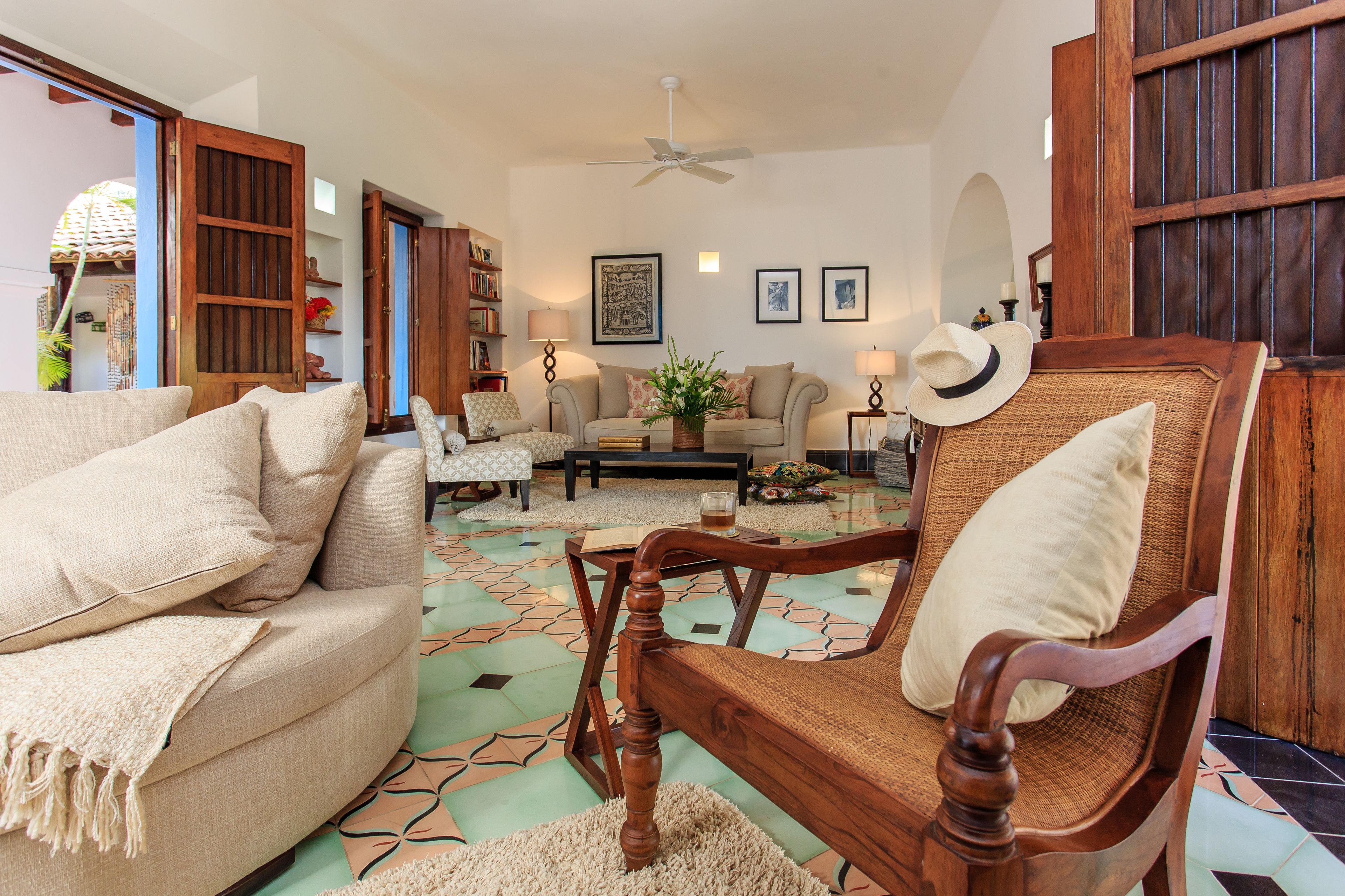 A living room with a sofa, a wooden chair, a coffee table, and a bookshelf.
