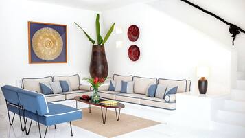 Un salon moderne avec un canapé, une table basse et un vase rempli de fleurs.