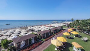 A beachside resort with multiple bungalow-style accommodations, outdoor seating areas, and a view of the sea. - Pine Beach Belek - All Inclusive (Serik)