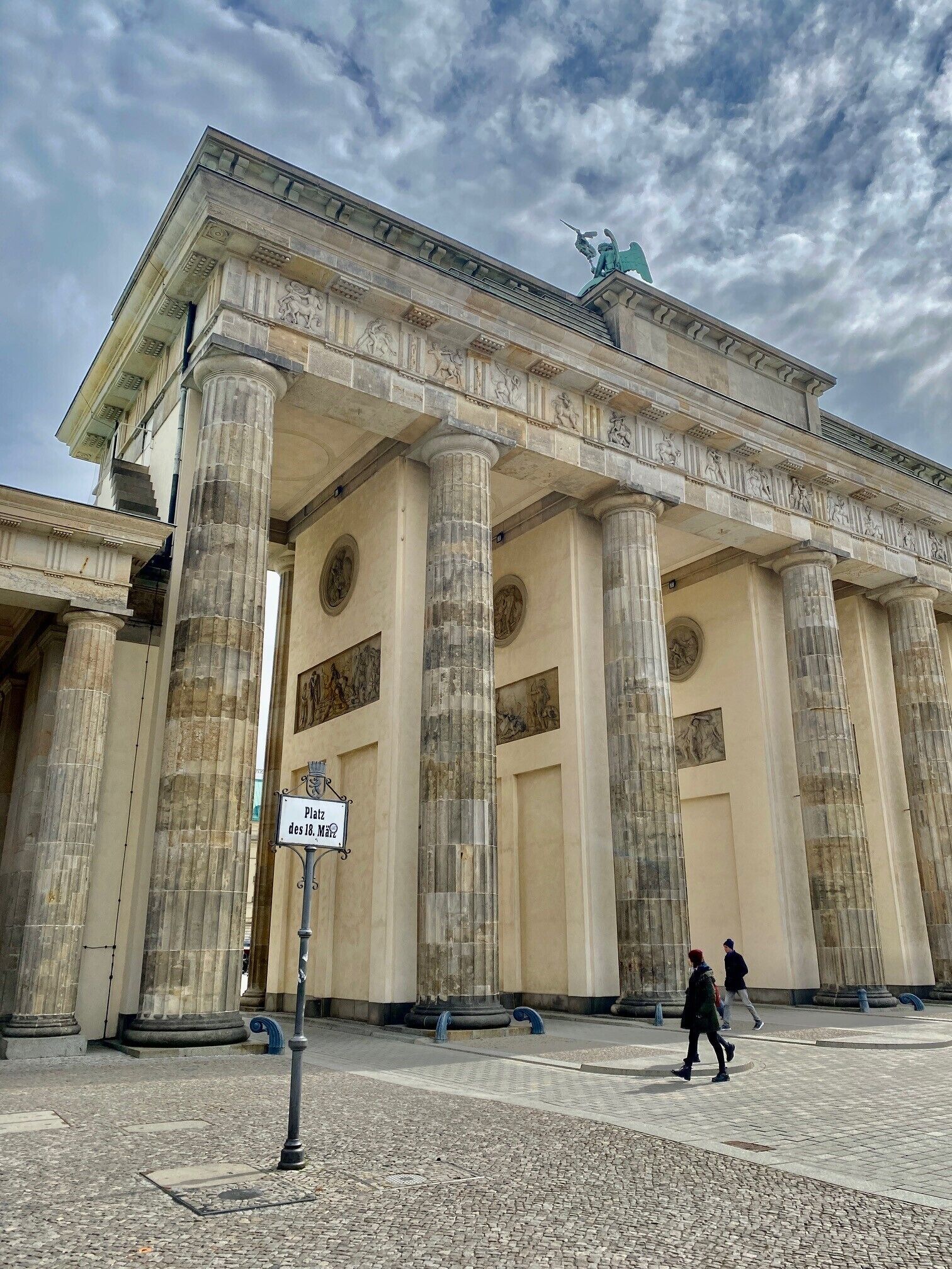 Un edificio clásico con grandes columnas y una estatua en el tejado.