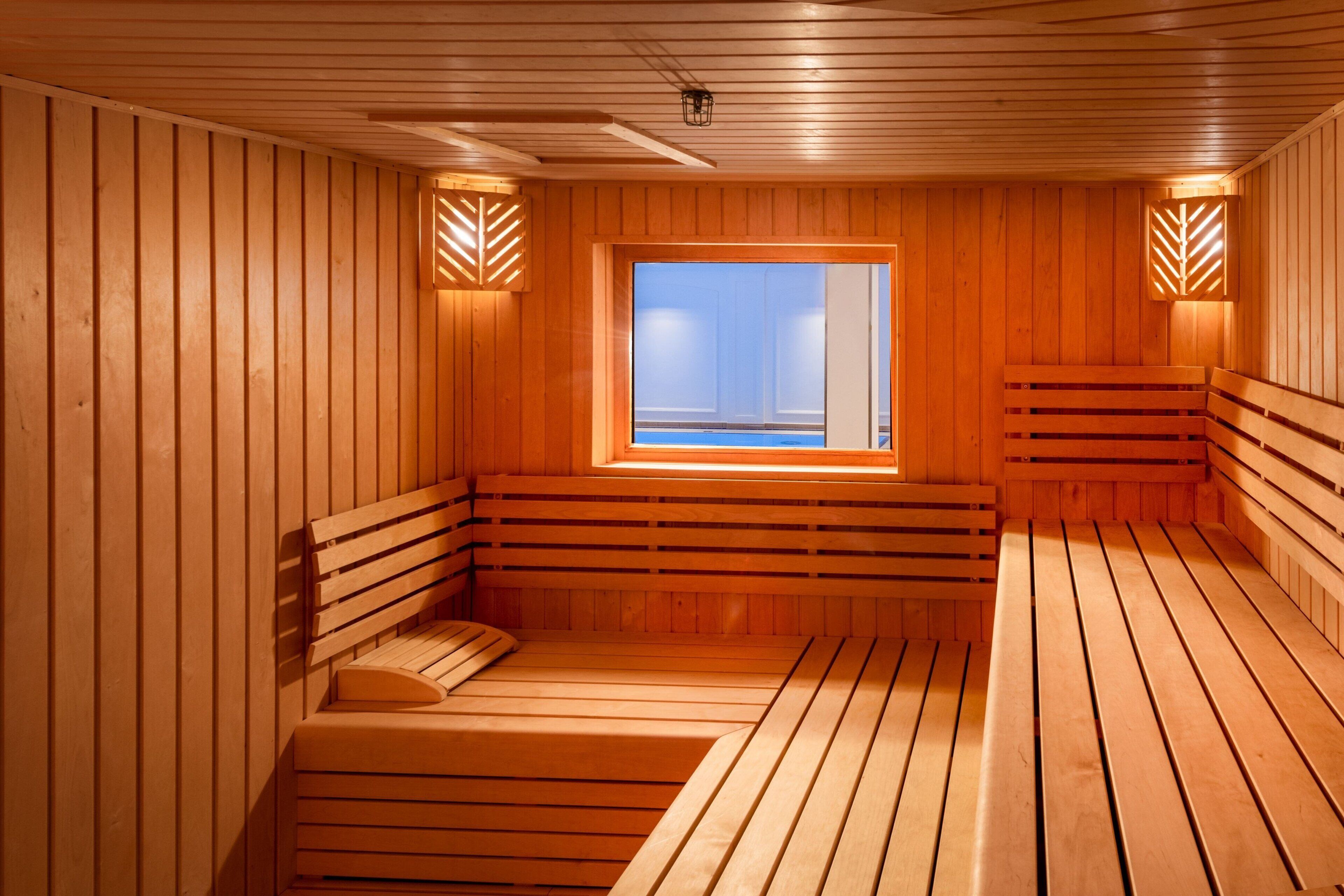 A sauna with wooden benches and a window with a view.
