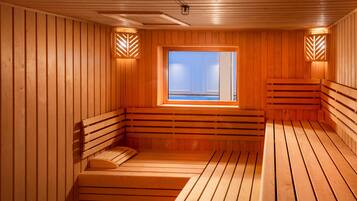 A sauna with wooden benches and a window with a view.