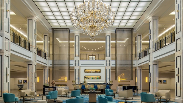 A spacious lobby with a grand chandelier, multiple seating areas, and a bar. - JW Marriott Hotel Berlin (Berlin)