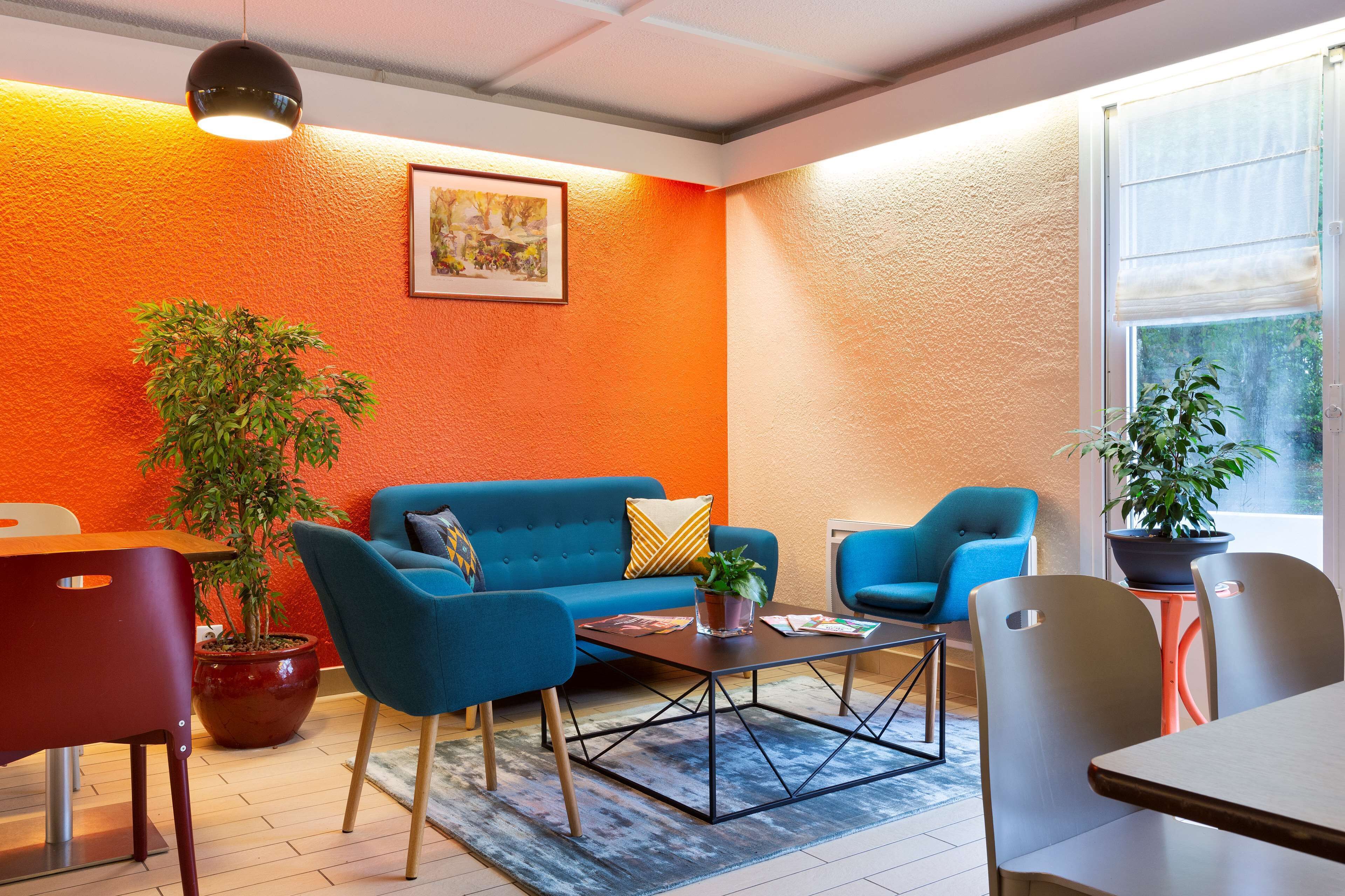 A modern living room with a blue sofa, a coffee table, and a potted plant.