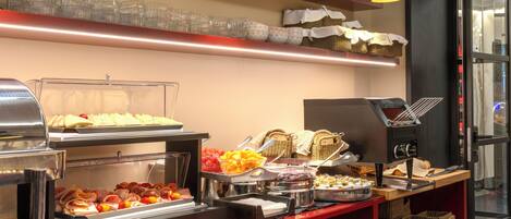 A buffet setup with various food items and glassware on display.