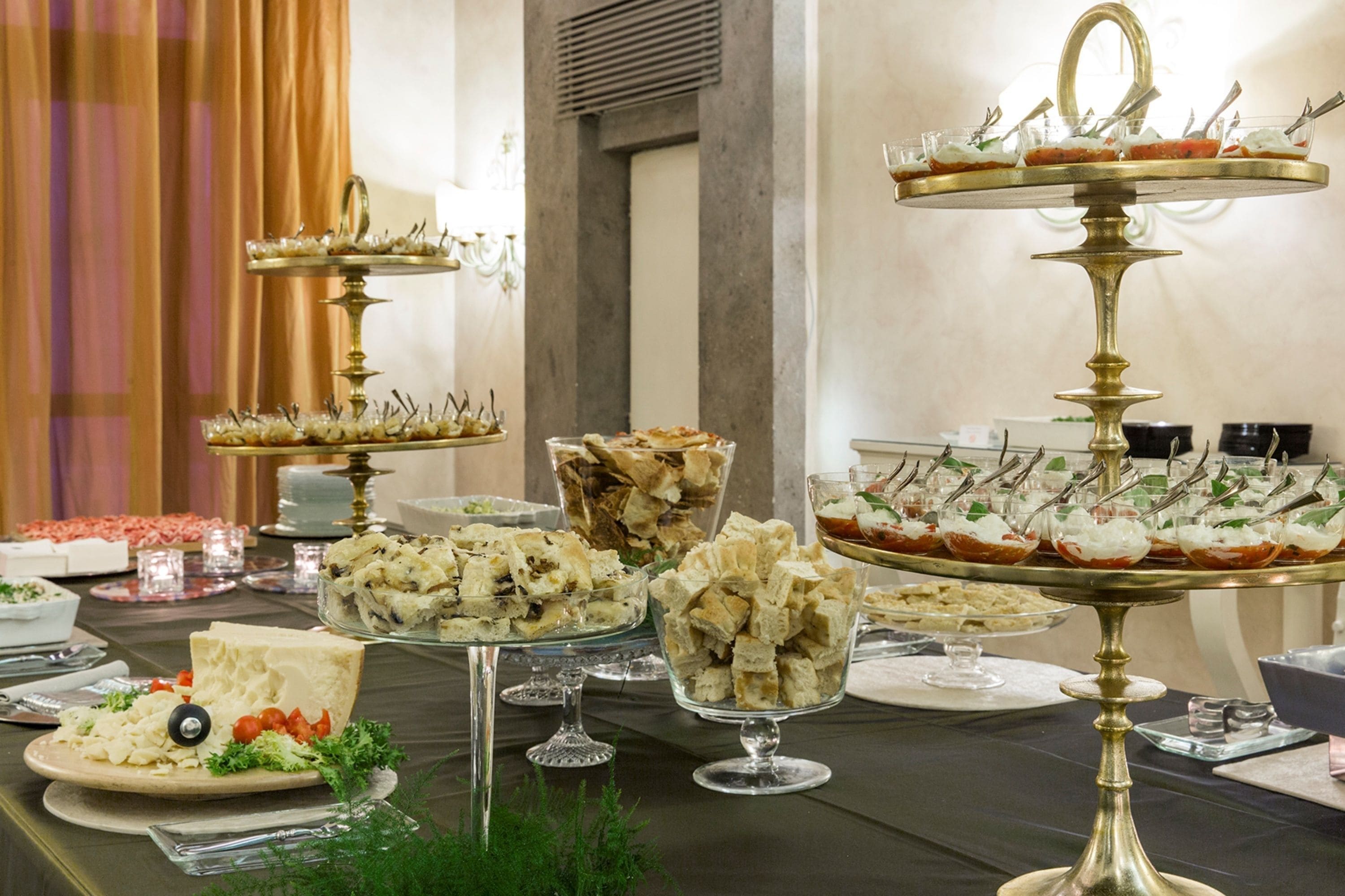 A buffet table with various food items and glassware.
