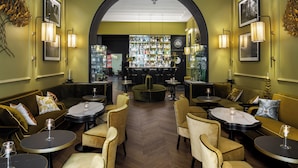 A restaurant with a bar area, seating arrangements, and a chandelier. - Hotel Adriano Rooftop (Rome)