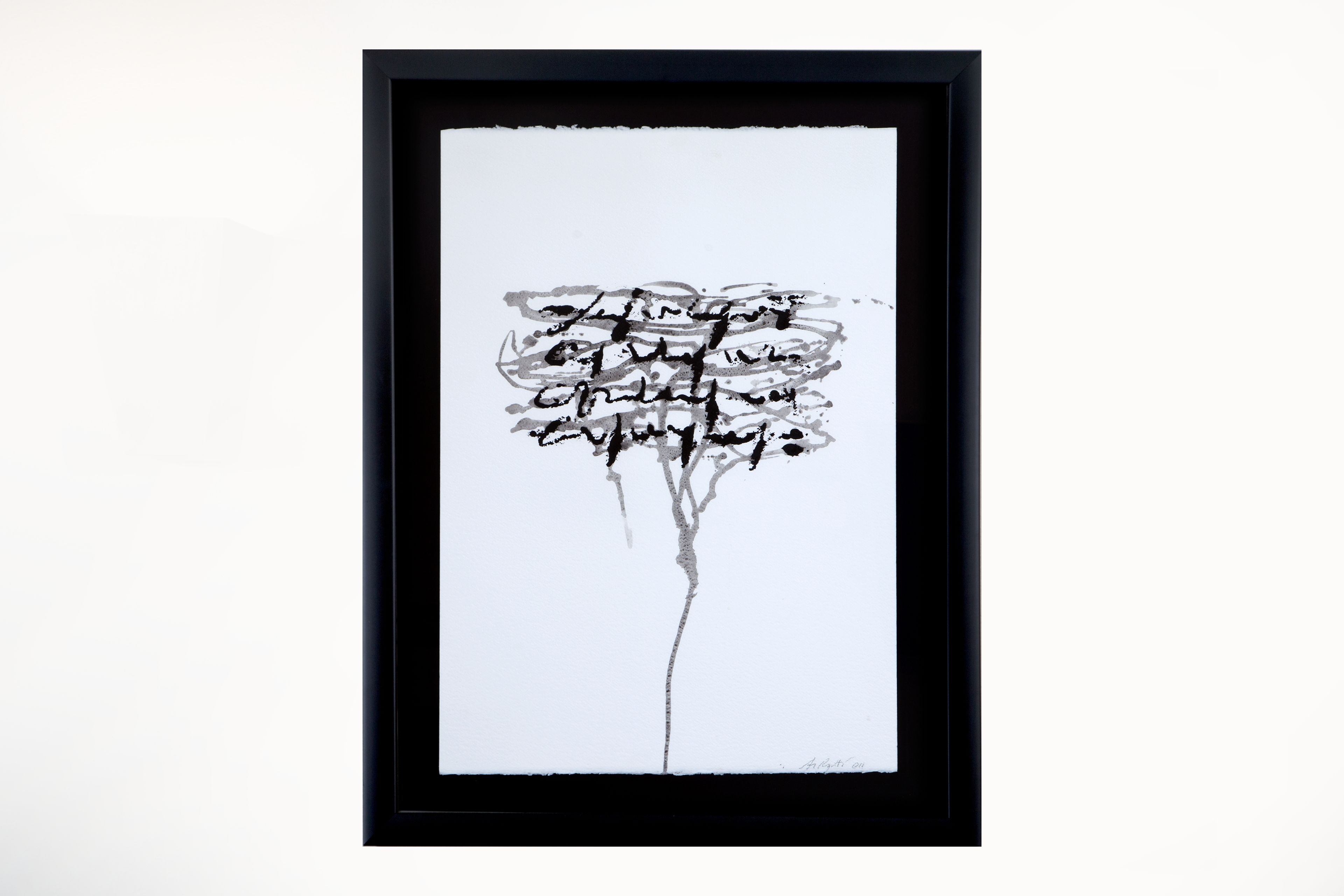 Une œuvre d’art encadrée, réalisée à l’encre noire sur papier blanc, représentant un arbre stylisé avec ses branches et ses feuilles.