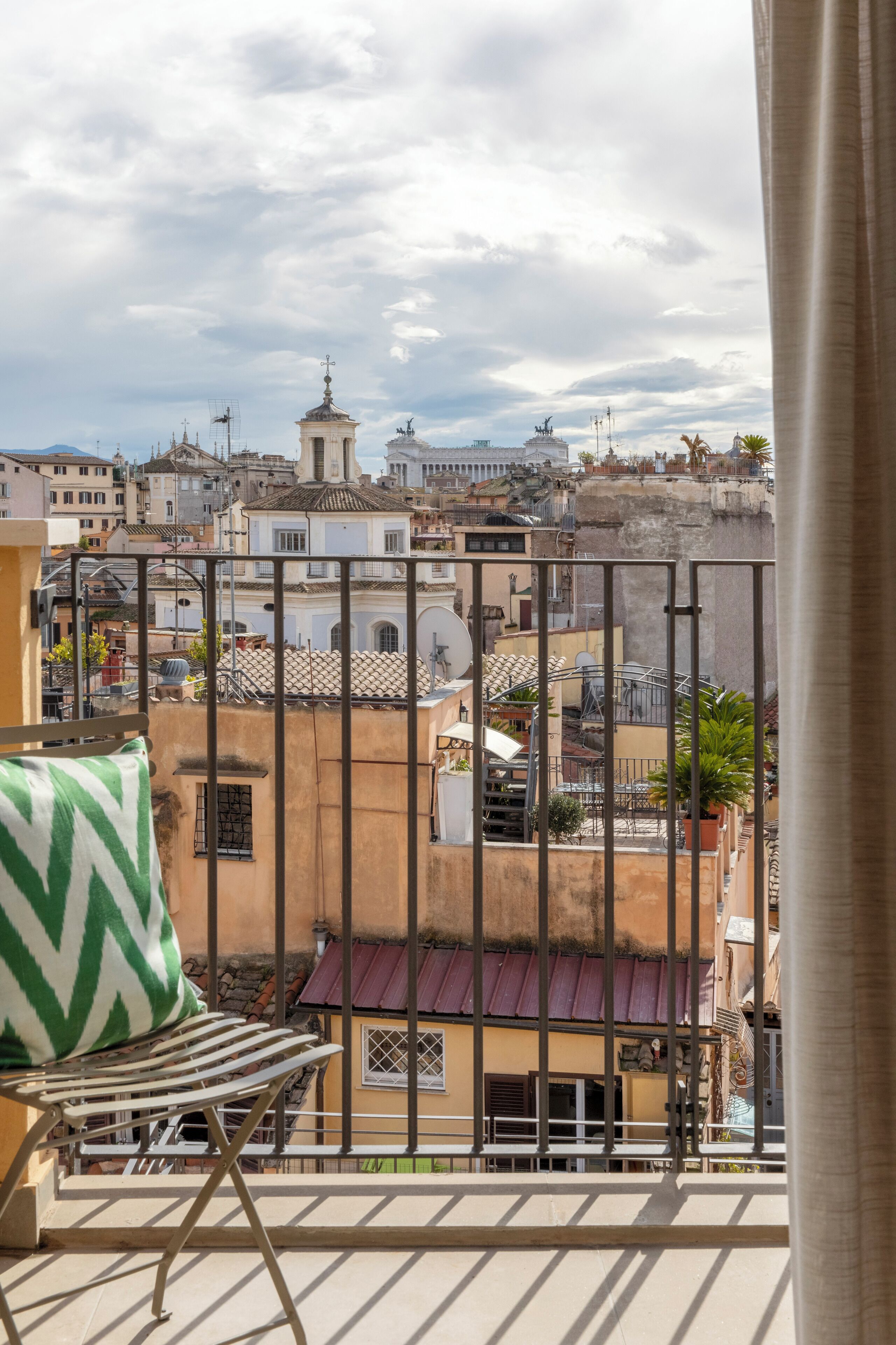 A balcony with a view of a cityscape, including buildings and a tower.