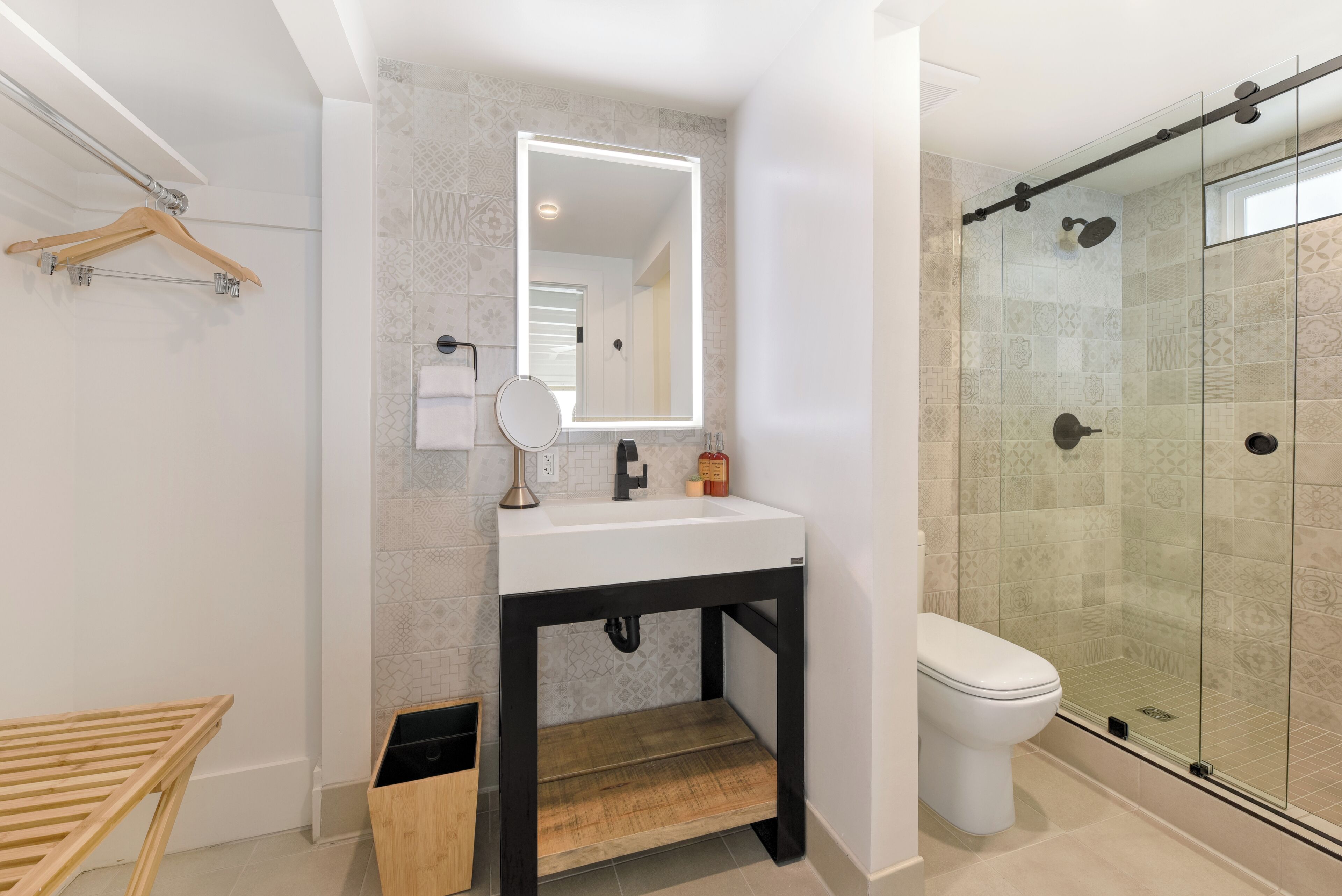 Une salle de bain moderne avec un lavabo blanc, un miroir et une douche à parois de verre.