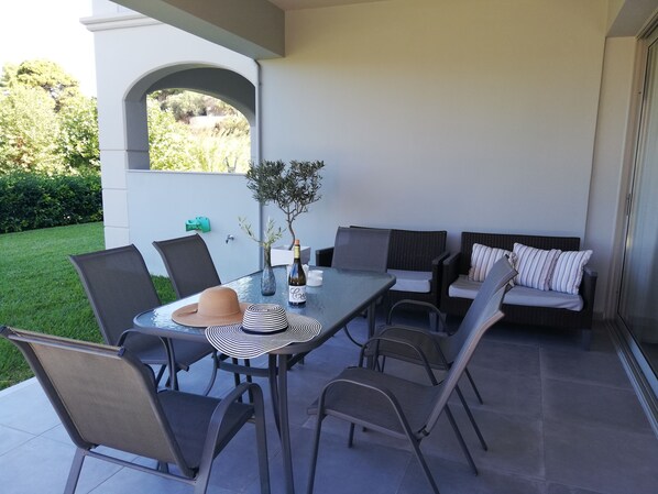 An outdoor patio with a table, chairs, and a sofa.