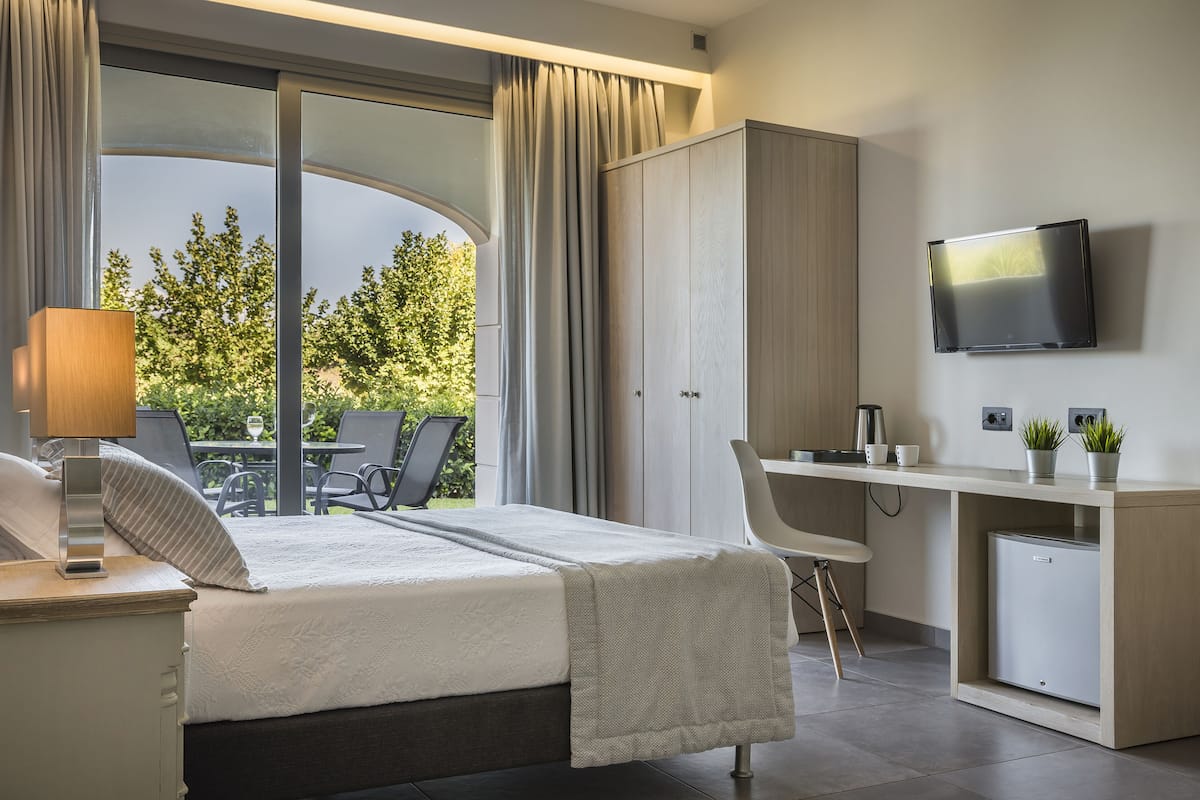 Ein modernes Hotelzimmer mit Bett, Schreibtisch und Sitzecke.
