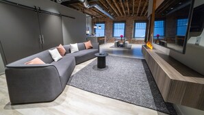A modern living room with a sectional sofa, a coffee table, and a fireplace. - Montvale Hotel (Spokane)