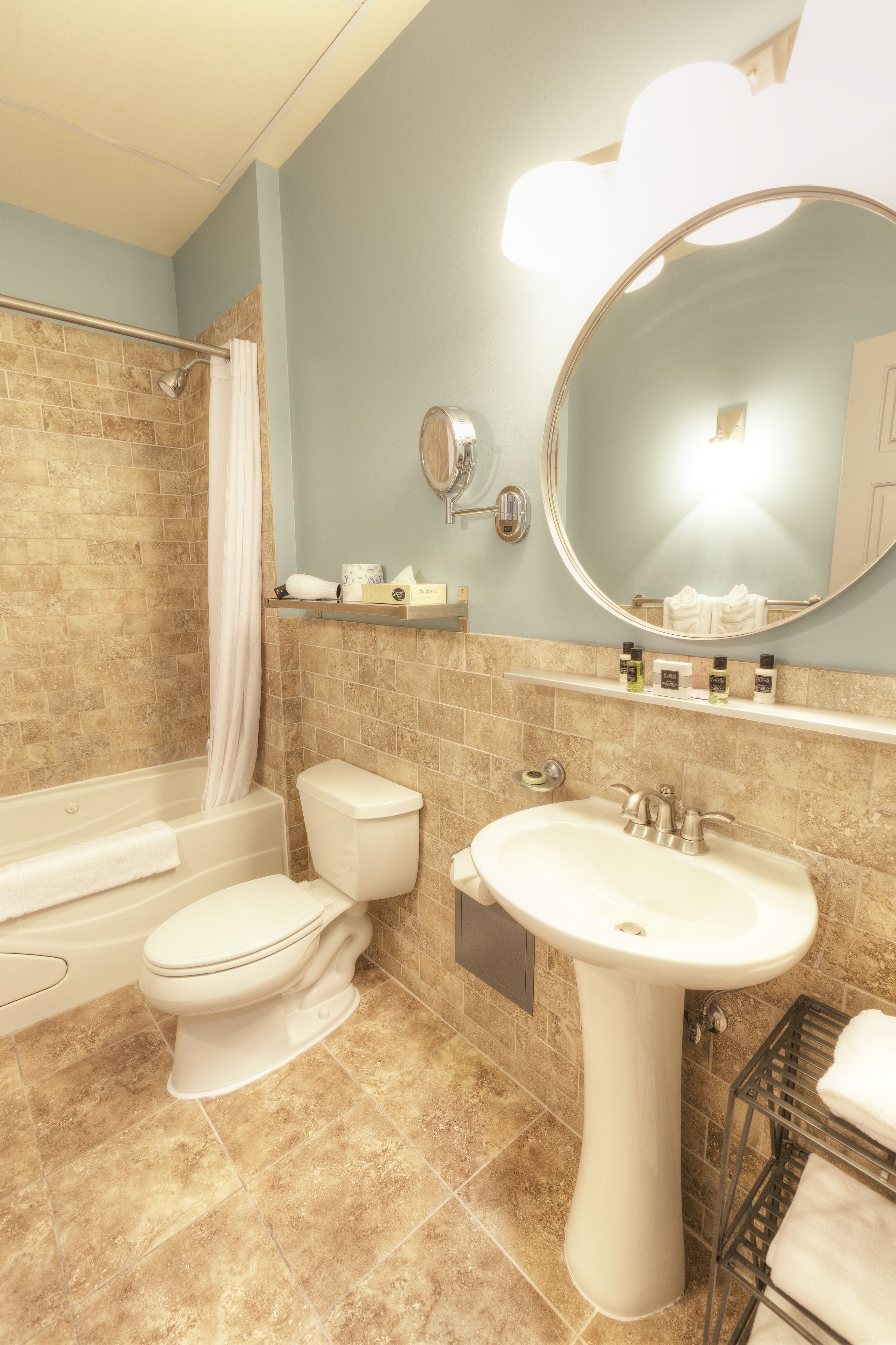 Une salle de bain avec une baignoire, des toilettes, un lavabo et un miroir.