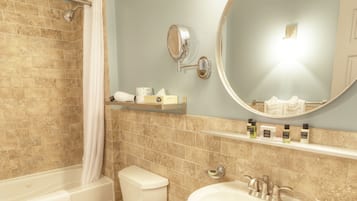 Une salle de bain avec une baignoire, des toilettes, un lavabo et un miroir.