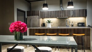A modern kitchen with a central island, bar stools, and a dining table. - Montvale Hotel (Spokane)