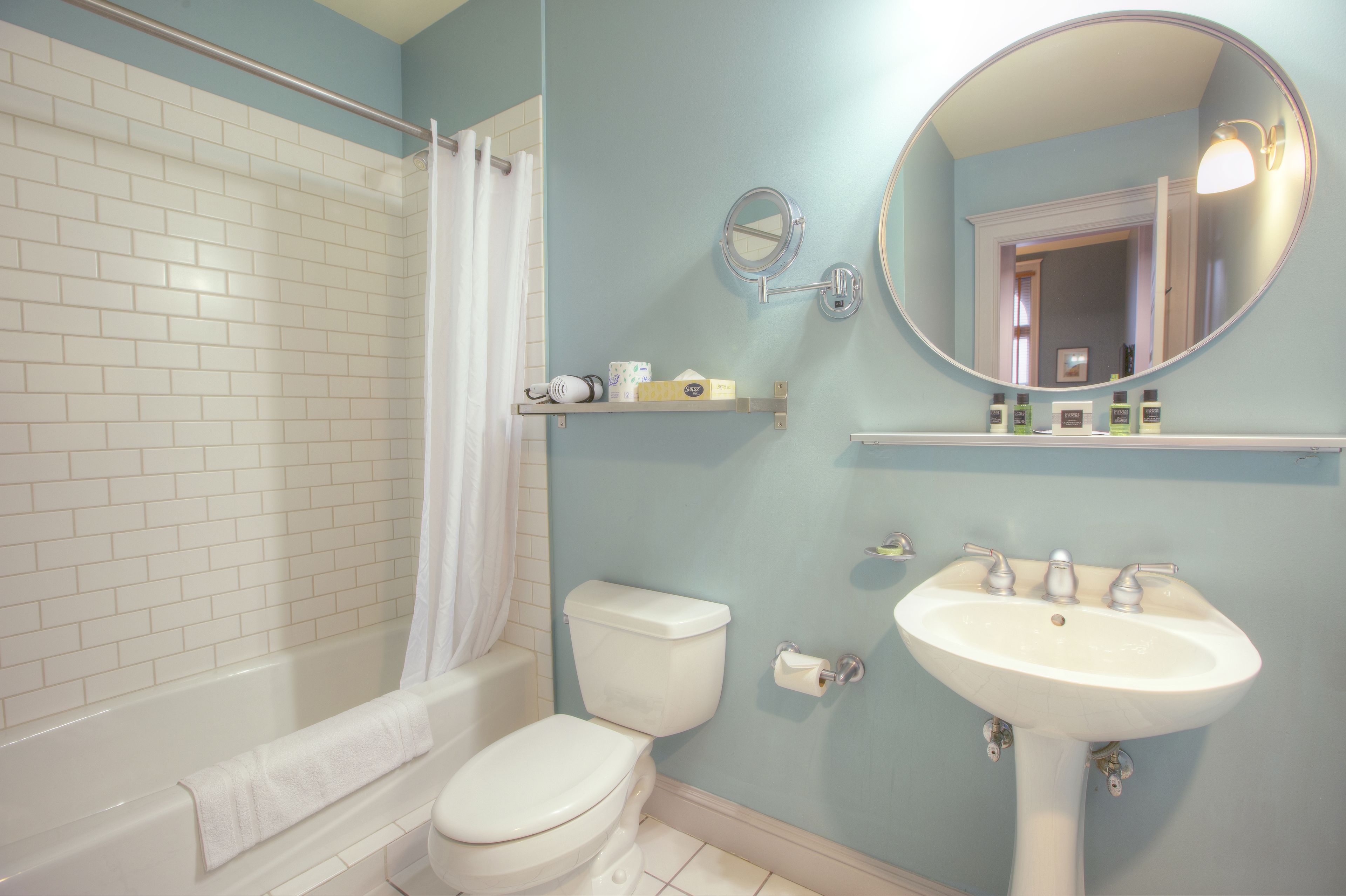 A bathroom with a white bathtub, a toilet, a sink, and a mirror.