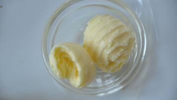 Una ciotola di vetro trasparente con due palline di gelato.