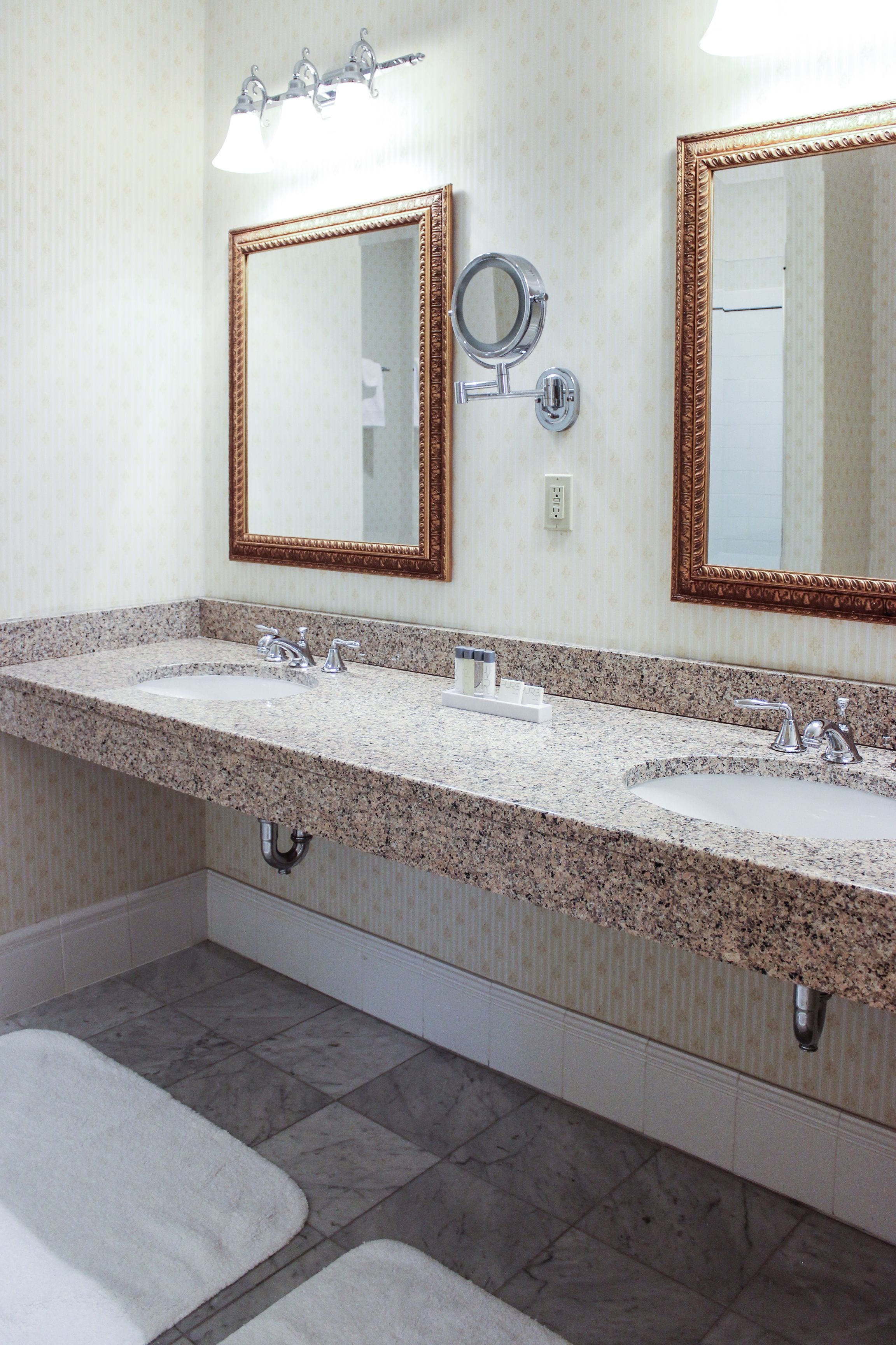 A bathroom with two sinks, a large mirror, and a towel rack.