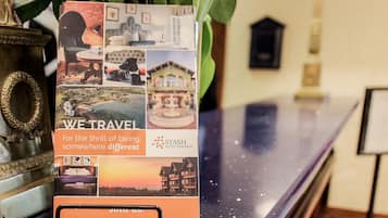 A travel brochure titled "WE TRAVEL for the thrill of being somewhere different" with images of various hotel interiors and landscapes.