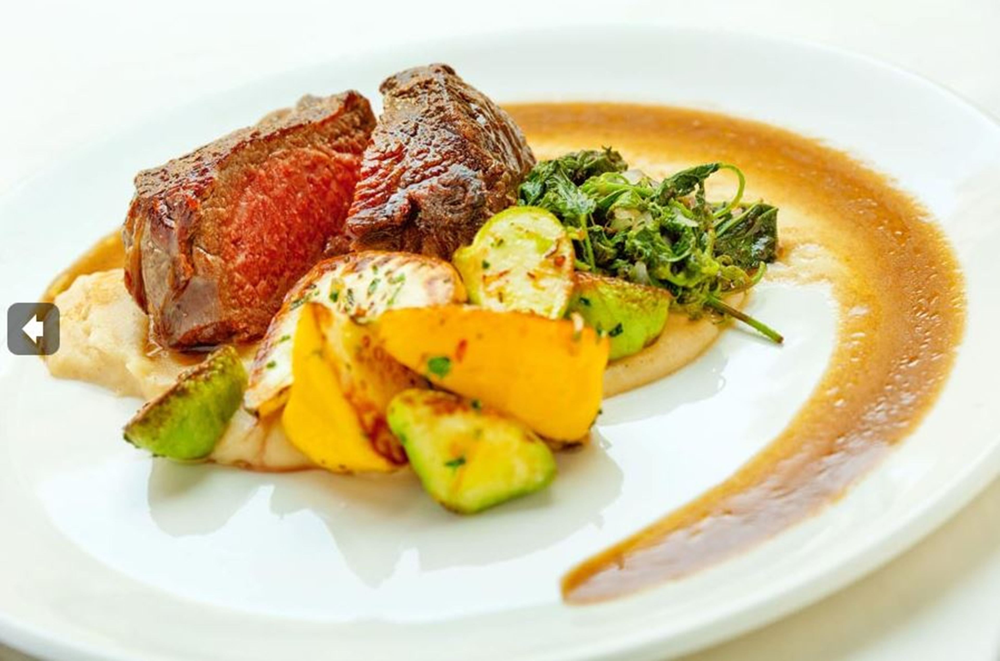Un piatto di carne con verdure arrosto e insalata.