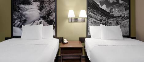 A hotel room with two beds, a nightstand with a phone, and wall-mounted lamps.