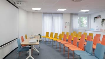 A conference room with a whiteboard, a projector, and a table with chairs.