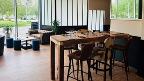 A modern dining area with a wooden table set for four, surrounded by leather and patterned chairs. - ibis Lyon Caluire Cité Internationale (Caluire-et-Cuire)