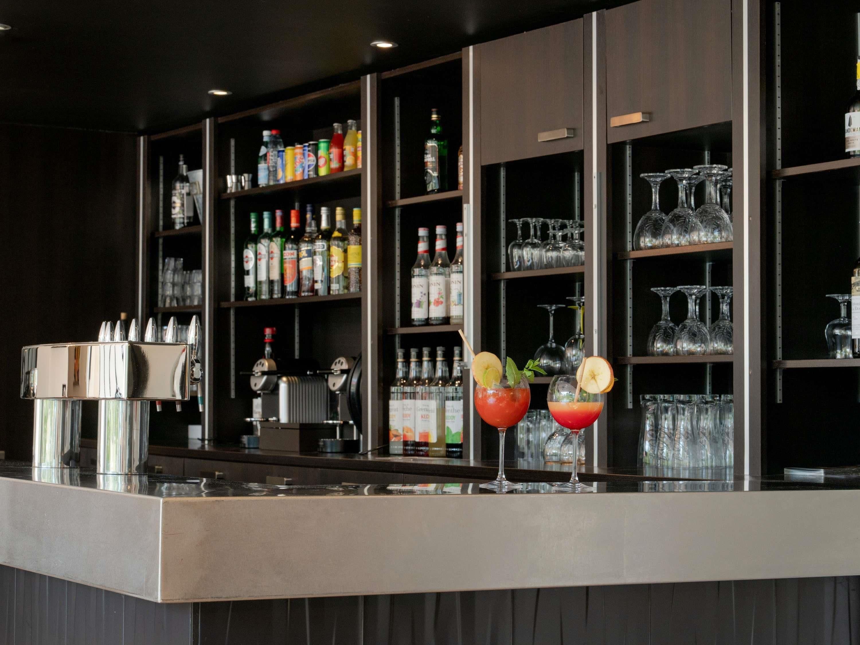 A bar area with shelves stocked with various bottles and glasses.