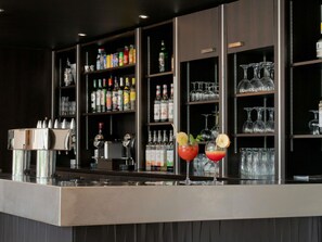 A bar area with shelves stocked with various bottles and glasses. - ibis Lyon Caluire Cité Internationale (Caluire-et-Cuire)
