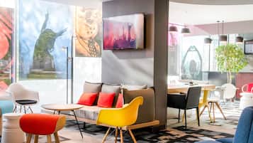 Un área de estar moderna con un sofá, sillas y una mesa de comedor.